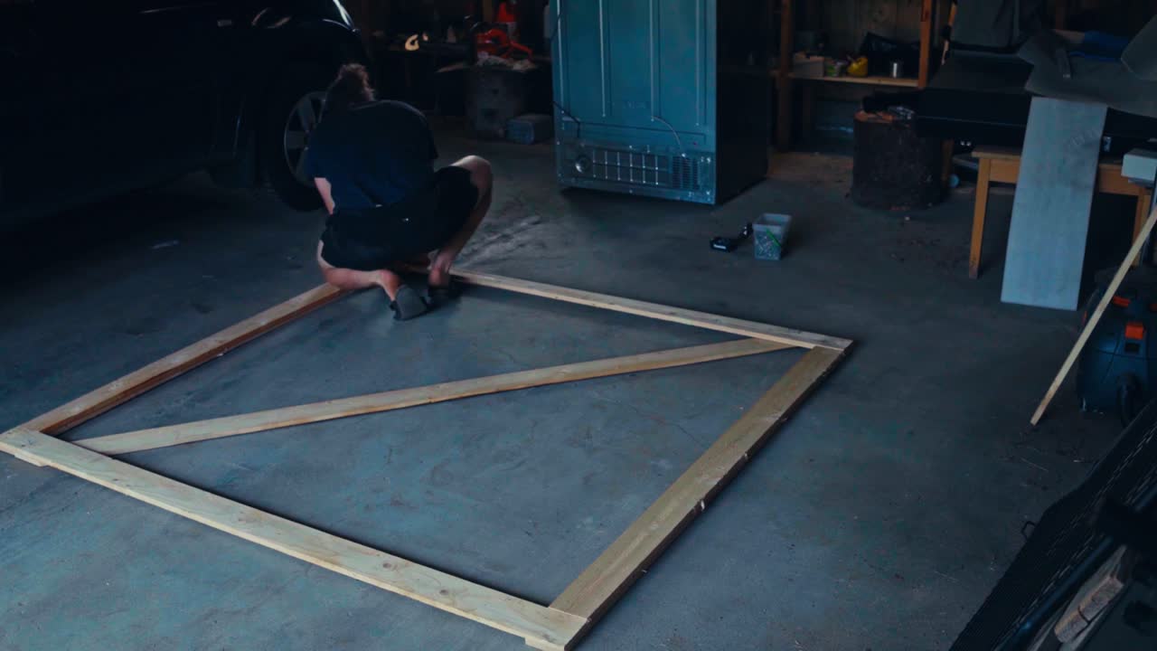 Time-lapse Of A Man Constructing A Wooden Frame With Wire Mesh