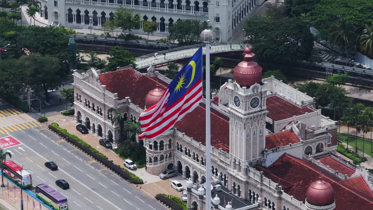 Drone orbiting the Malaysian flag in downtown Kuala Lumpur, sunny day in Malaysia