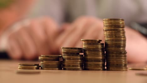 closeup of male hand stacking coin in home budgeting concept