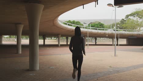 rear view of woman wearing hijab running outside