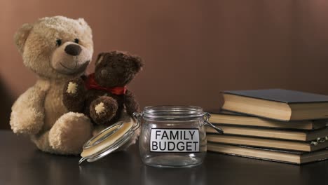 man puts money into empty jar for family savings