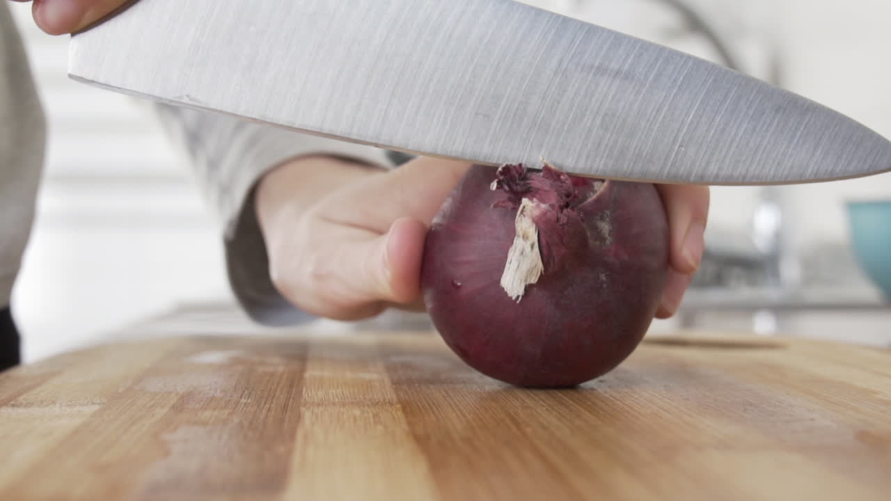 cámara lenta como cortar los extremos de una cebolla morada preparándose para pelarla en la cocina