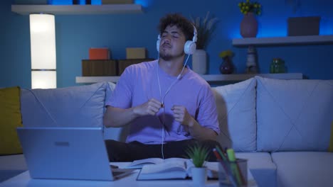 Joven-Estudiante-Universitario-Escuchando-Música-Y-Bailando-Por-La-Noche-En-Casa.