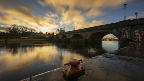 Timelapse-of-Carrick-on-Shannon-town-bridge-in-county-Leitrim-and-Roscommon-with-traffic,-people-and-moving-sunset-evening-clouds-on-river-Shannon-in-Ireland