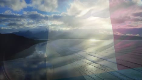 digital composition of france flag waving against aerial view of waves in the sea