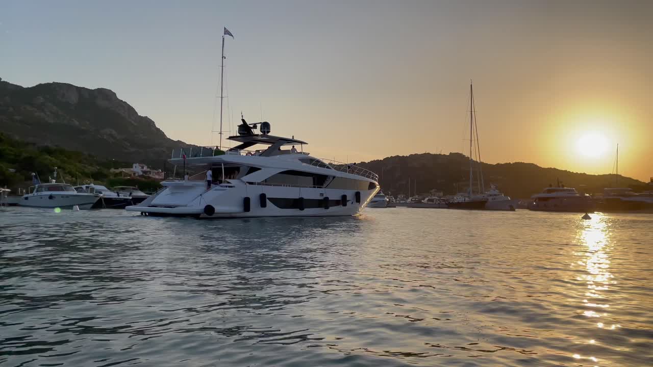 vista panorámica de un yate de lujo en el puerto de porto cervo al atardecer, italia