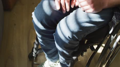 primer plano de un hombre discapacitado caucásico sentado en silla de ruedas en casa