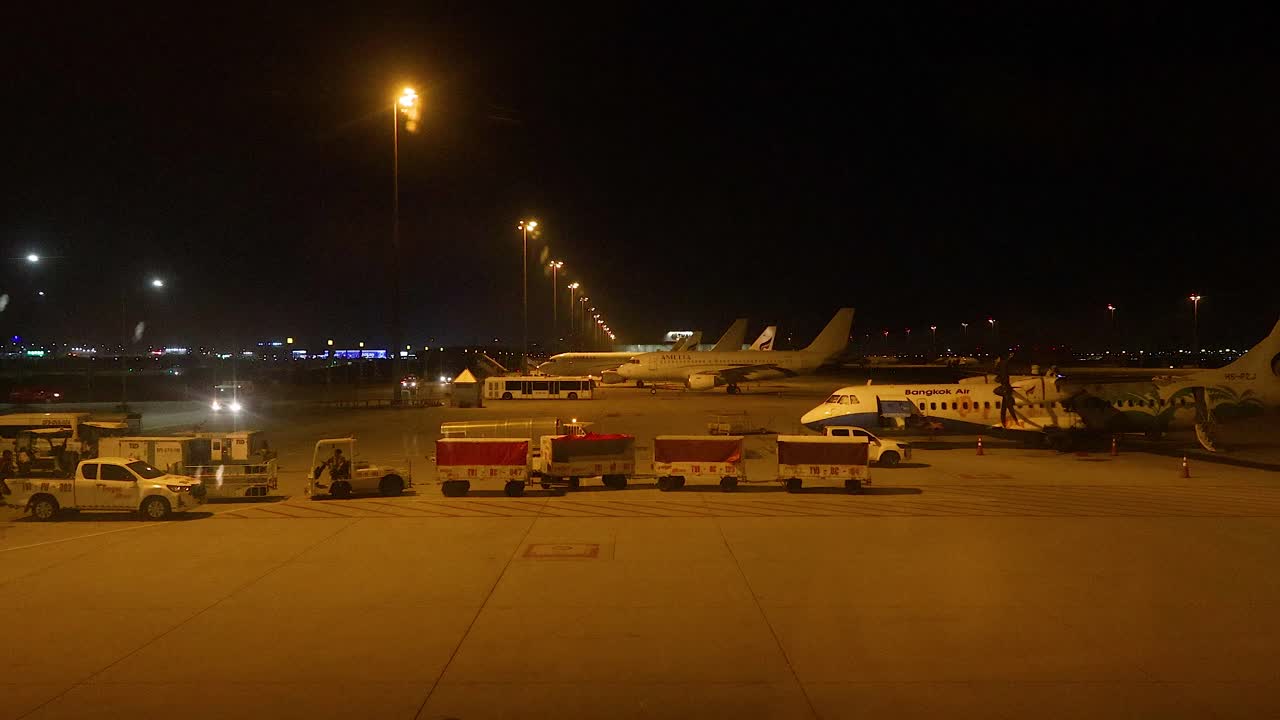 escena nocturna del aeropuerto con aviones y personal de tierra