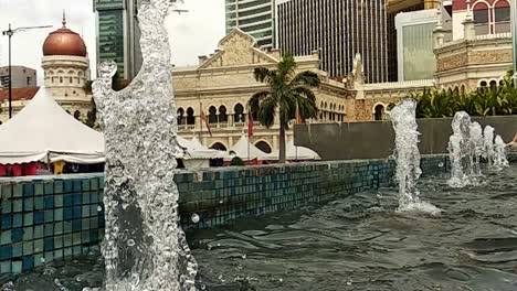 Close-up-or-fountain-water-drops-to-small-pool-in-the-city