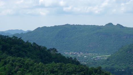 las nubes se mueven hacia la derecha y las sombras caen sobre las montañas mientras se ve un pueblo debajo, lapso de tiempo, punto de vista de dong phaya yen, parque nacional khao yai, tailandia