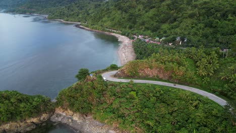 impresionante vista aérea de una motocicleta conduciendo por un acantilado en la exuberante isla de catanduanes, filipinas