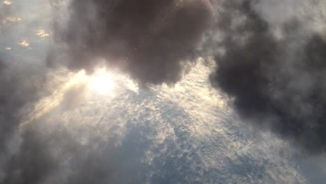 atmosphere, the sun shining among clouds in the sky