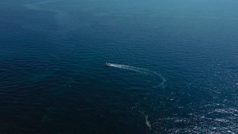 Flying-above-a-vacation-yacht-ship-boat-in-a-blue-clear-water-seaside-bay-in-the-idyllic-Adriatic-mediterranean-sea-ocean-by-the-Croatian-coast-with-blue-sky