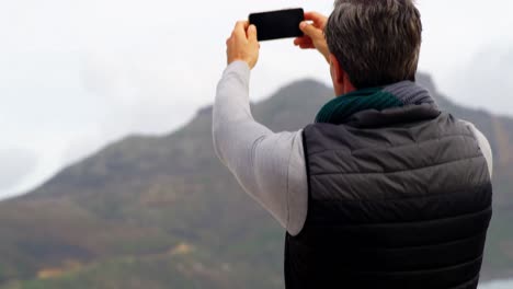 Reifer-Mann,-Der-Die-Aussicht-Vom-Mobiltelefon-Aus-Fotografiert