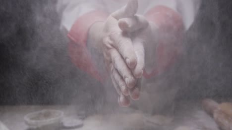 cook-slaps-his-hands-full-of-flour-creating-a-cloud-of-dust