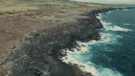 4k aerial dry volcanic coast on cloudy day drone dolly in shot