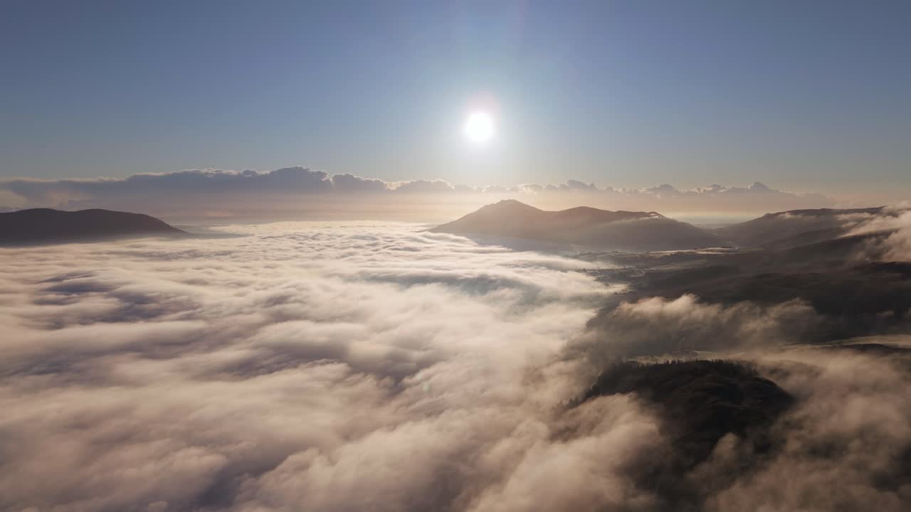 아일랜드의 오메아스 (omeath) 와 칼링포드 (carlingford) 근처의 안개 구름과 굴곡된 산 위에서 황금빛 해가 뜨는 모습.