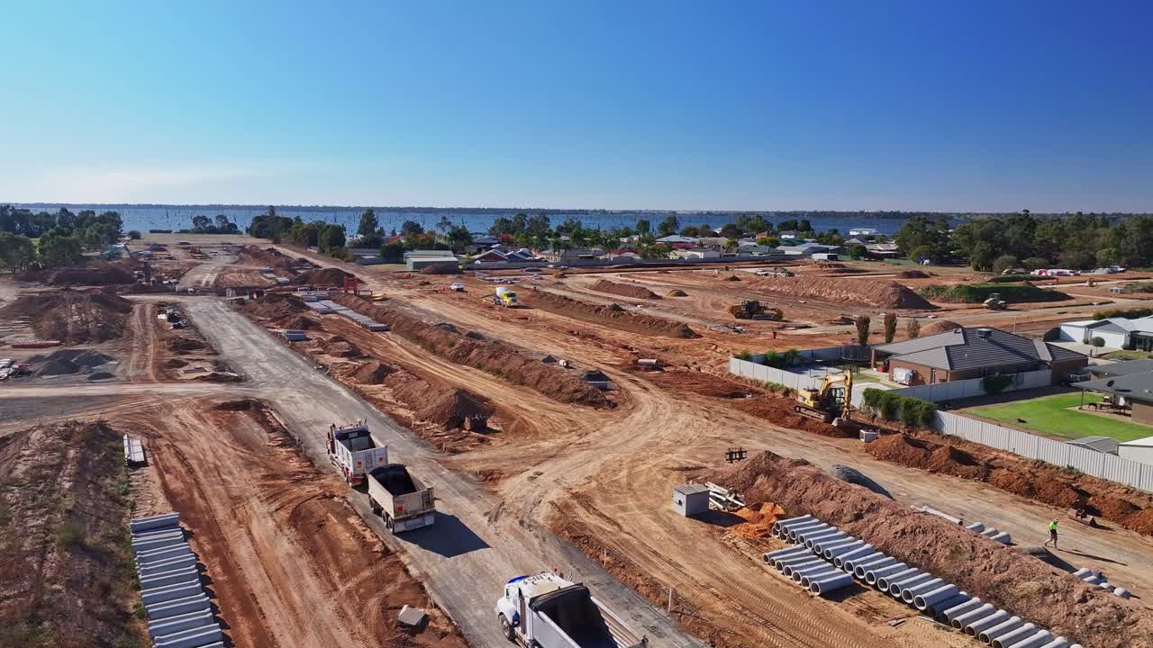 Large construction site with earthmoving equipment and pipes near residential area in Yarrawonga