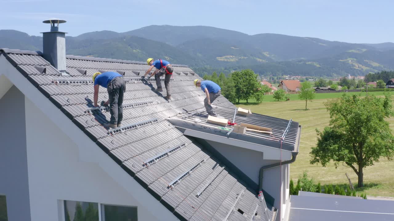Men working on roof of suburban dettached house. Installation works