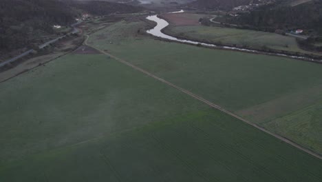 Reveal-shot-of-Praia-de-Odeceixe-along-Ribeira-de-Seixe-river-during-sunrise,-aerial