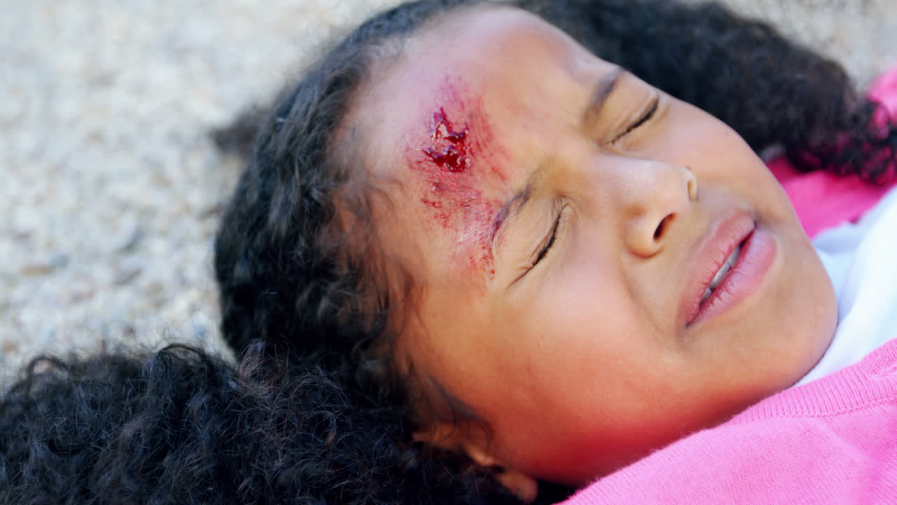niña inconsciente caída en el suelo después de un accidente