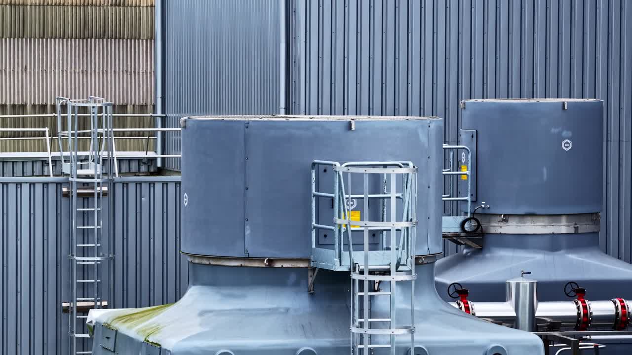 Torri di raffreddamento e impianto industriale su un tetto, sistema energetico di produzione