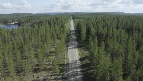 4k drone shot over a road going through beautiful forest landscape in sweden