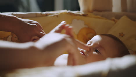 madre interactuando con el bebé en la cuna