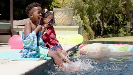 happy african american siblings eating ice cream at pool, in slow motion