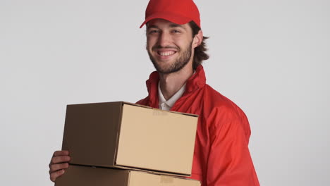 caucasian delivery man in front of camera on white background.