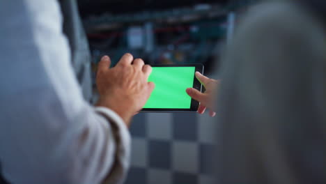 las manos del ingeniero sosteniendo una computadora tablet con pantalla de tecla chroma en la instalación de la granja.