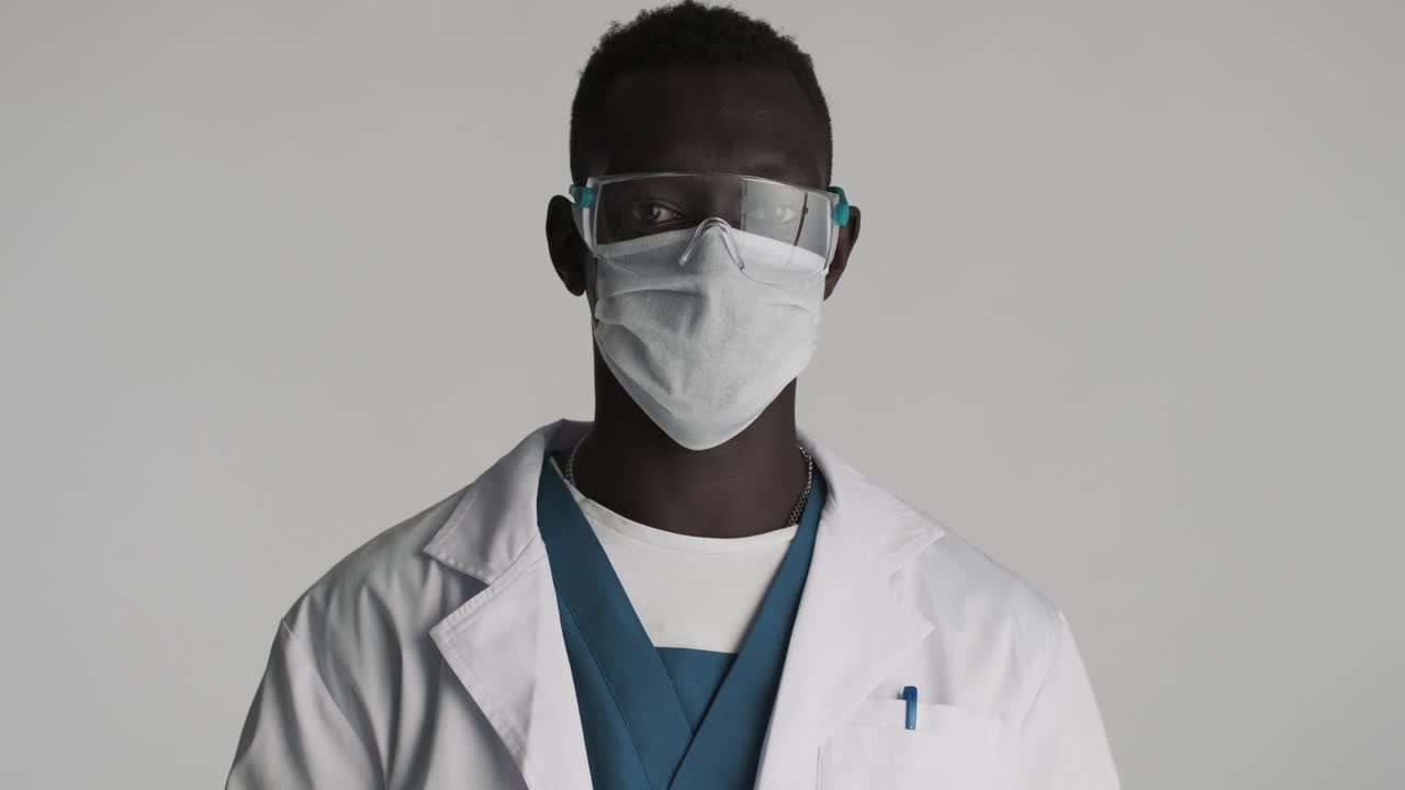 счастливый афроамериканский доктор на сером фоне.