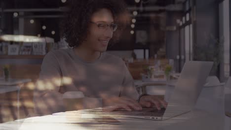 animation of smiling woman using laptop in cafe over sped up commuters walking in city