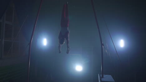 gymnast performing gymnastic cross exercise on gymnastic rings. shot in slow motion.