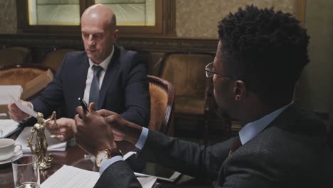 african american lawyer speaking with business partner in office