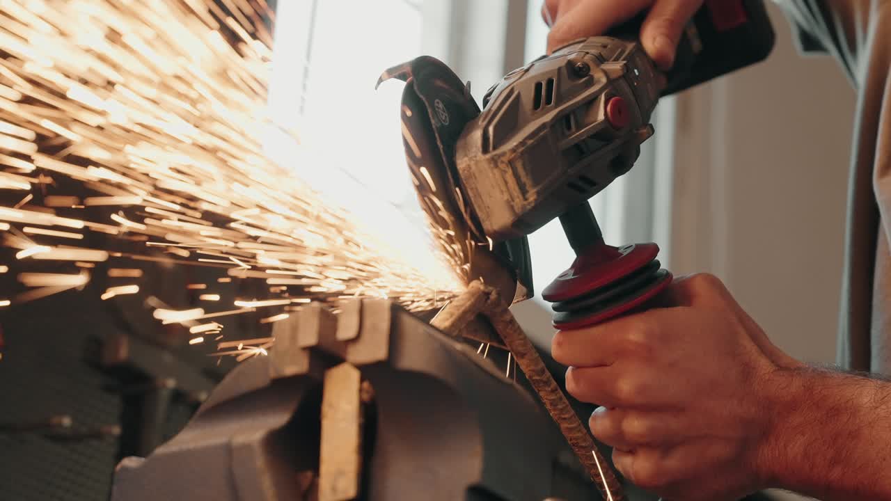 worker grinding steel bar with sparks in slow motion inside workshop setting