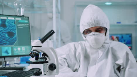 professional scientist in protection suit looking tired at camera