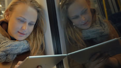 woman using tablet in subway train