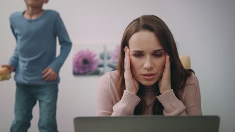 stressed mother looking laptop at home. woman calm down son