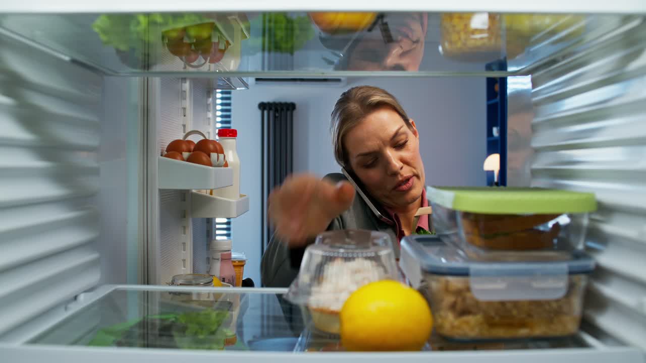 mujer comprobando el contenido del refrigerador