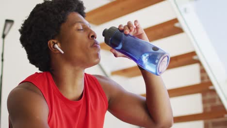 hombre afroamericano en forma haciendo ejercicio en casa y descansando cansado en casa
