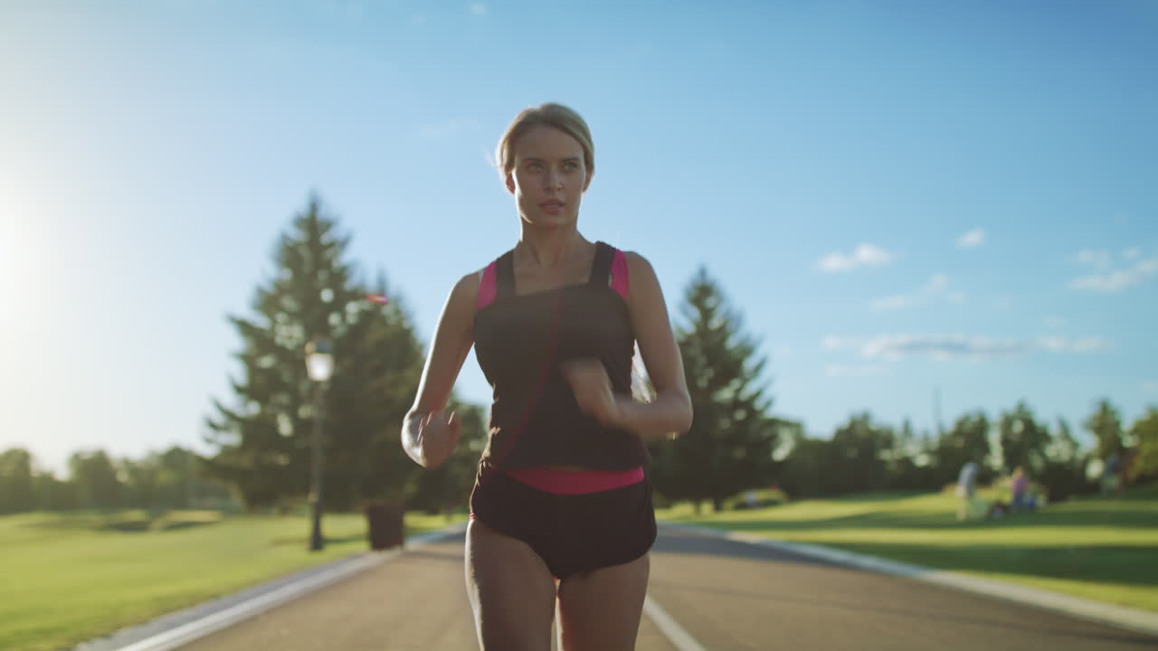 Woman runner running in slow motion. Sport woman running on park road