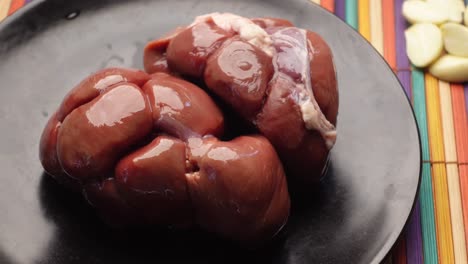 riñones de cordero crudos en una tabla de cortar ,