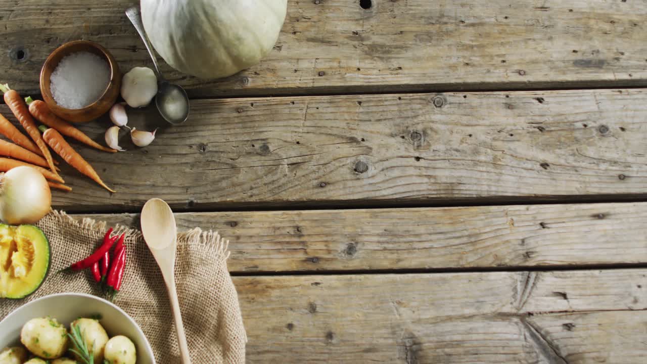 vista aérea de patatas cocidas y múltiples ingredientes alimentarios en una superficie de madera