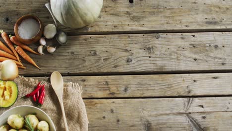 vista aérea de patatas cocidas y múltiples ingredientes alimentarios en una superficie de madera