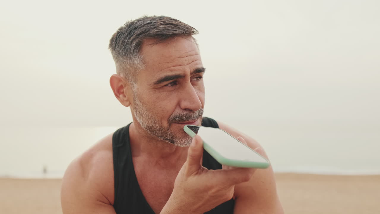 hombre usando el teléfono en la playa