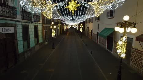 drone footage of the christmas decorations in the colorful streets of puebla city, with the cathedral in the background