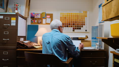woodworker in his office filling out paperwork