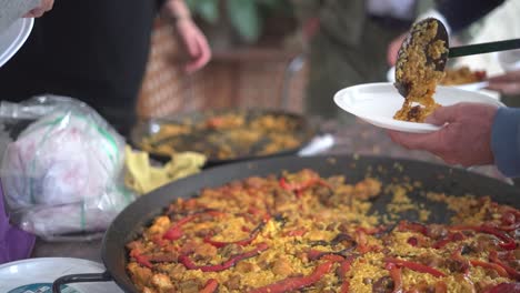 sirviendo paella a una reunión de personas que celebran