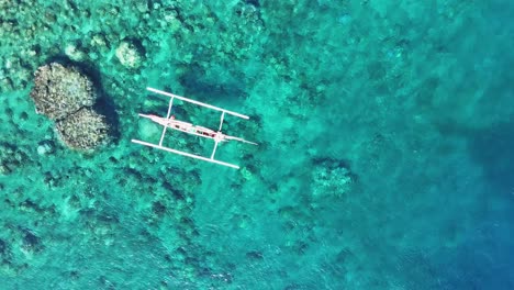 Pescador-Local-Pescando-Desde-Un-Barco-Tradicional-Sobre-Un-Hermoso-Fondo-De-Coral-Y-Turquesa.